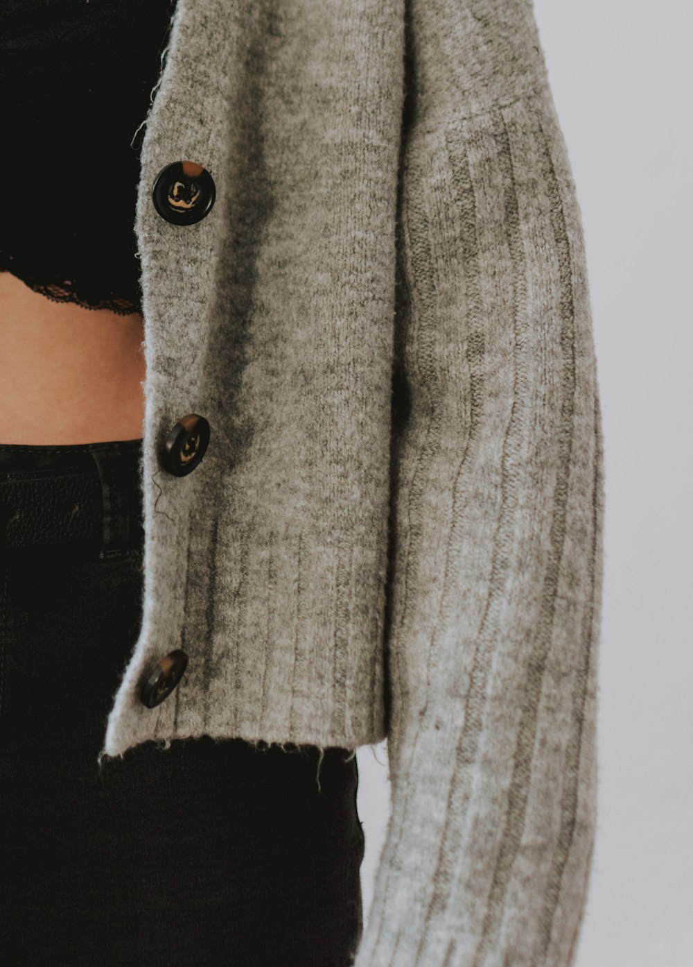 person wearing gray knit button-up sweater