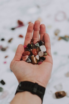 Close-up of hands holding mineral samples with a notebook nearby.