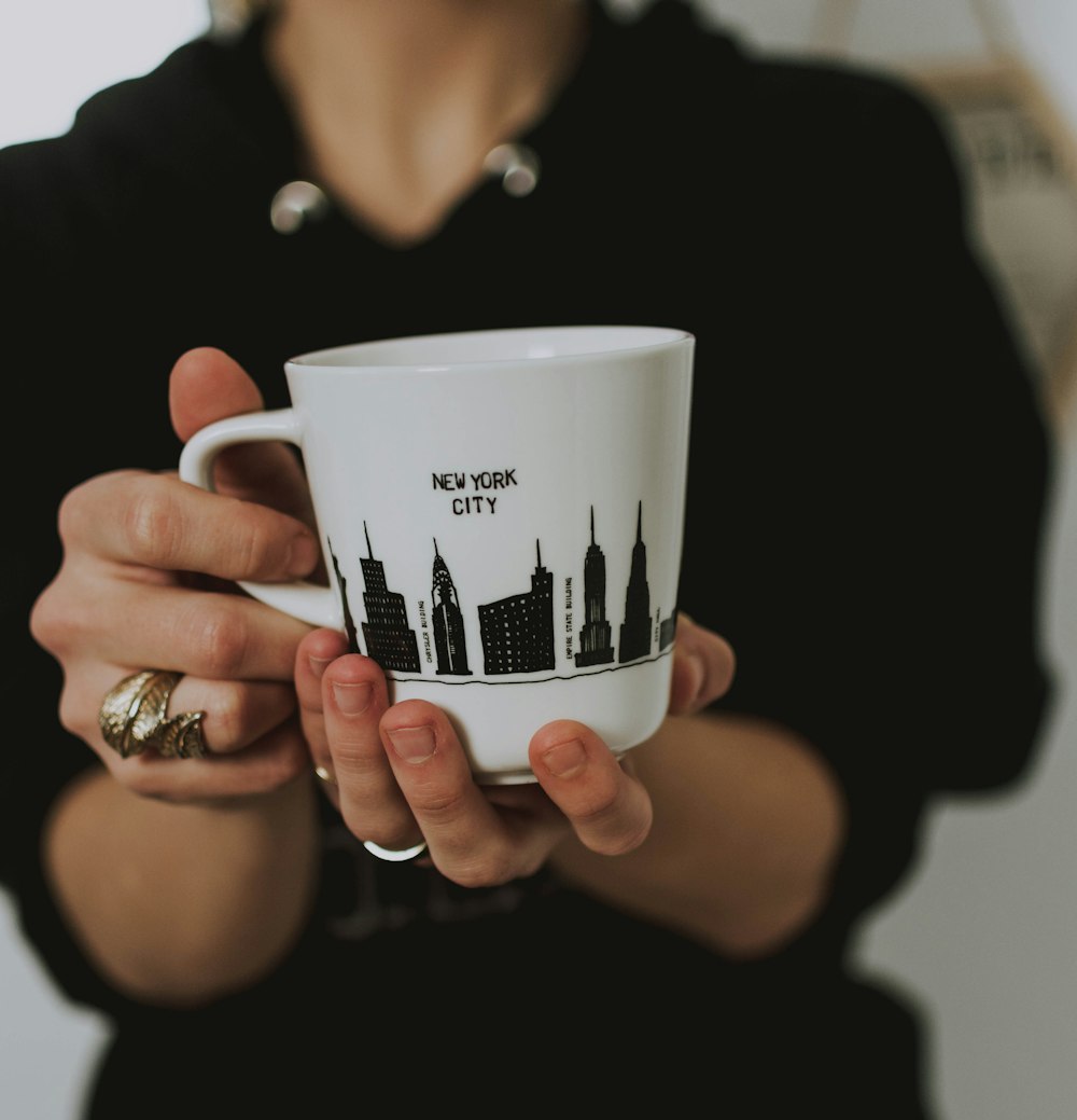 person holding white ceramic mug