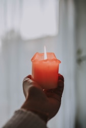person holding pink lighted candle