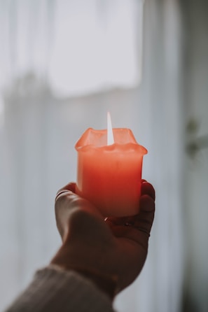 person holding pink lighted candle