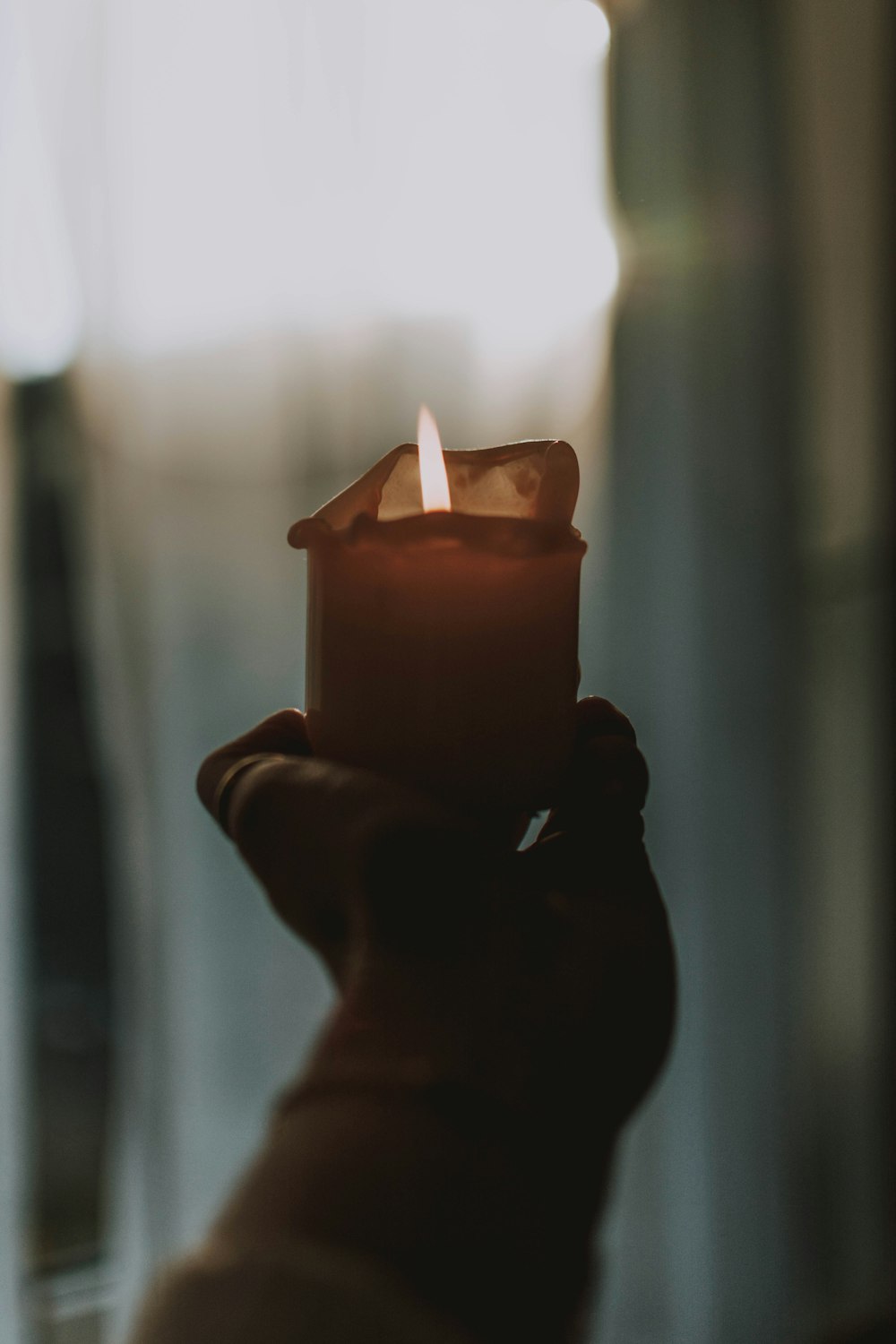 person holding pink lighted candle