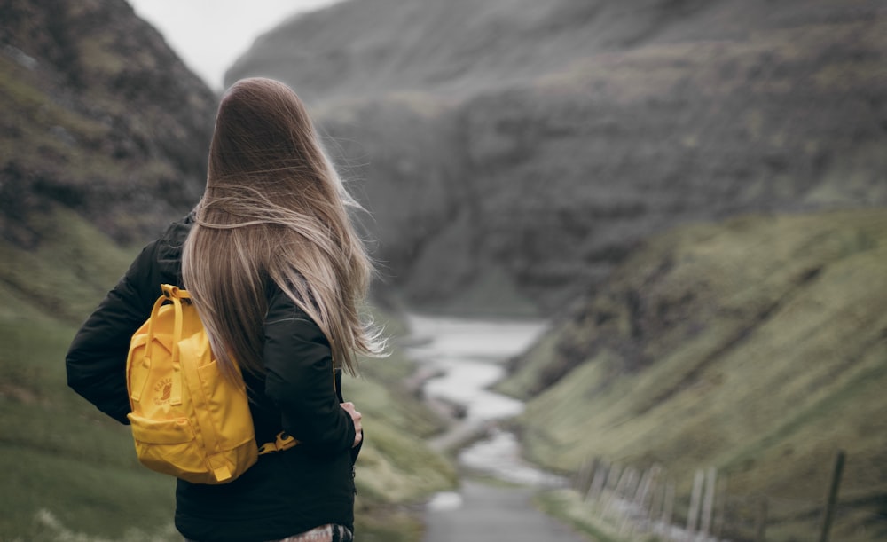 woman standing on cliff during daytime