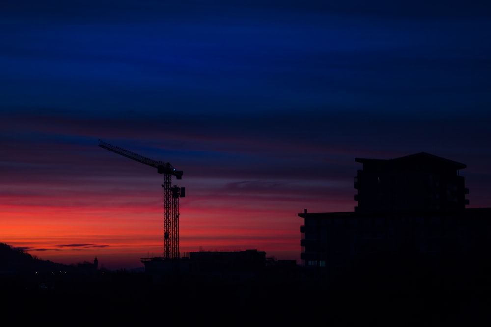 silhouette of tower crane during golden hour