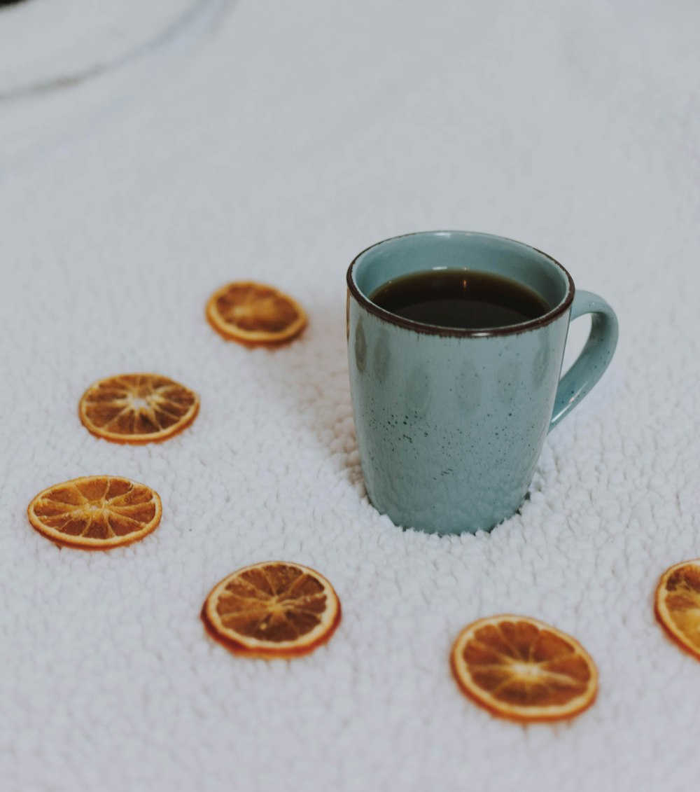 black coffee in green ceramic mug near sliced lemon