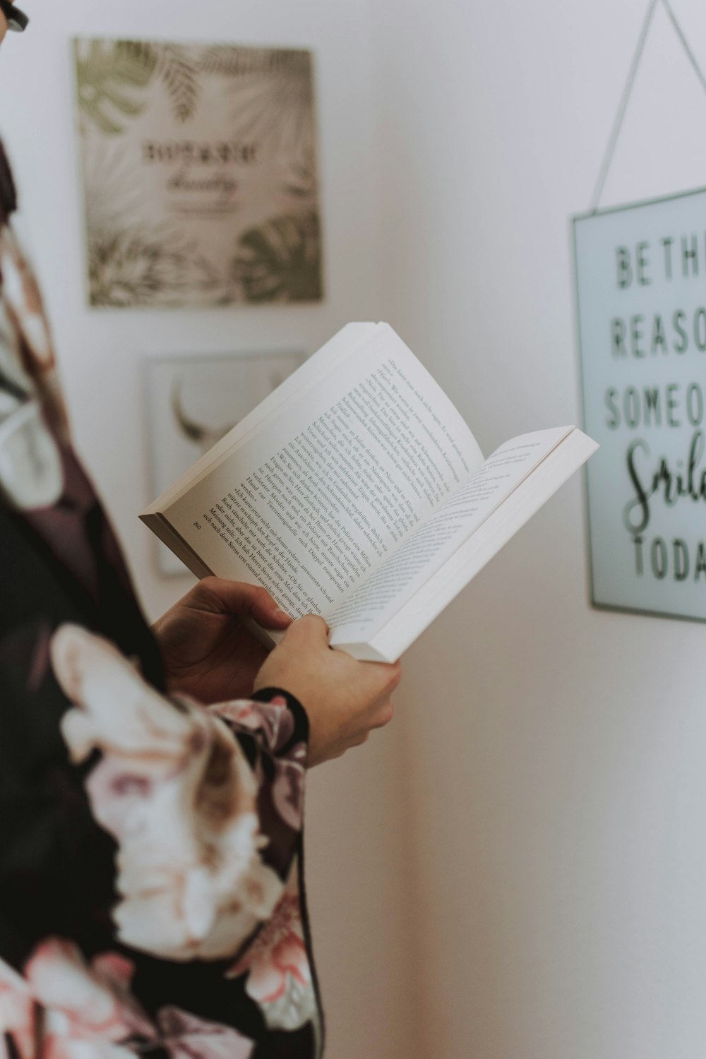 selective focus photography of standing woman holding book