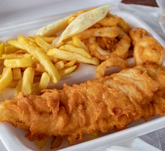 cooked meat and French fries in white disposable plate