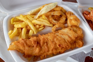 cooked meat and French fries in white disposable plate