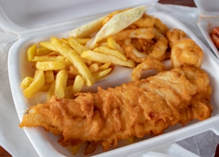 cooked meat and French fries in white disposable plate