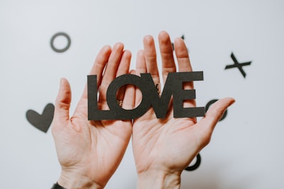 person holding love word cutout paper careful zoom background