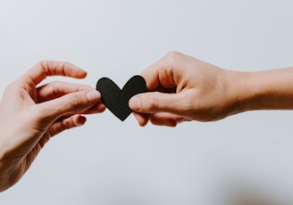 two person holding papercut heart