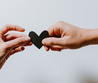 two person holding papercut heart