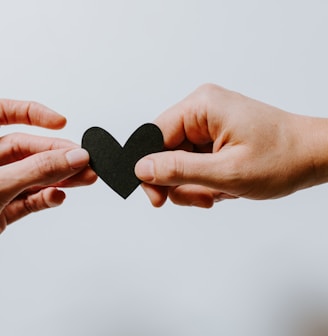 two person holding papercut heart