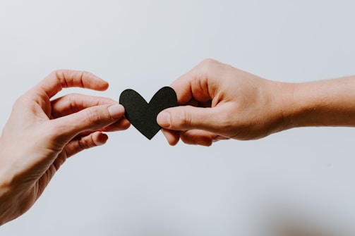 two person holding papercut heart