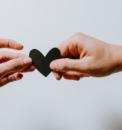 two person holding papercut heart