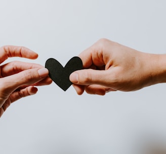 two person holding papercut heart