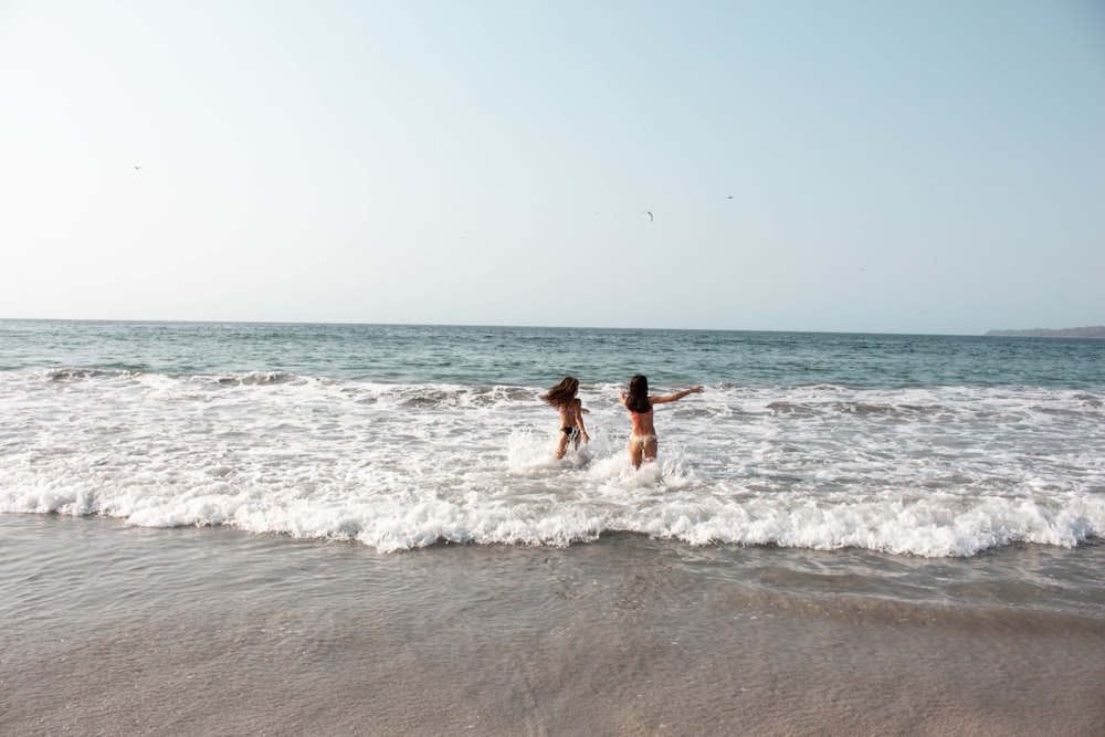 two person standing on the seashore