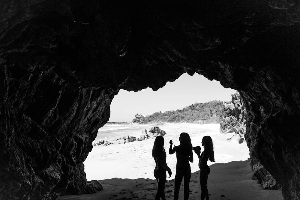 silhouette of three woman near the body of water