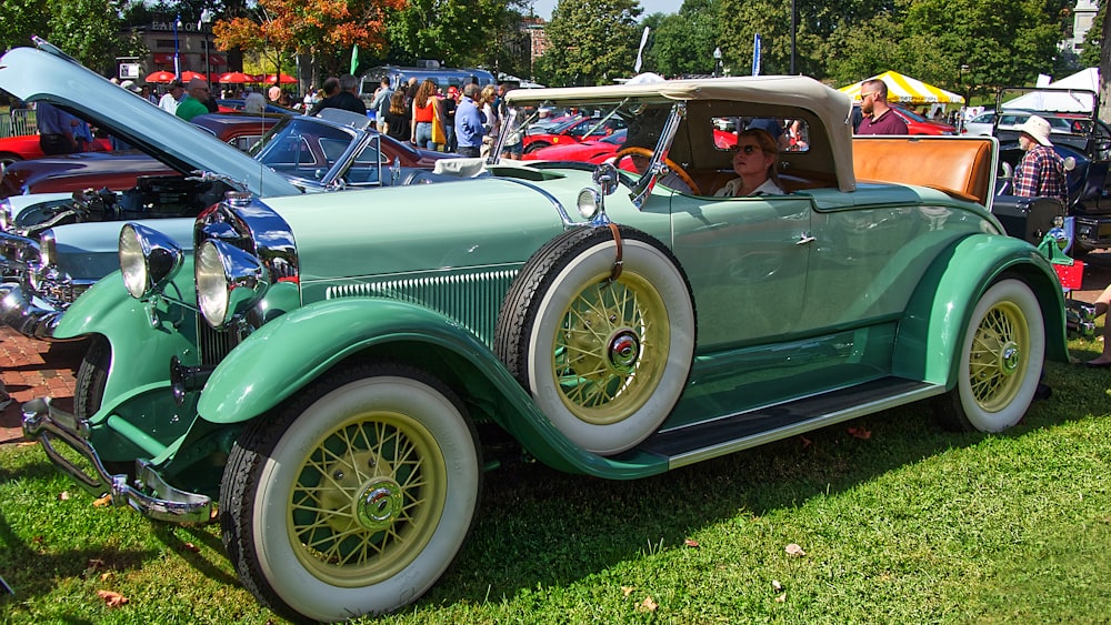 woman riding on teal vintage coupe