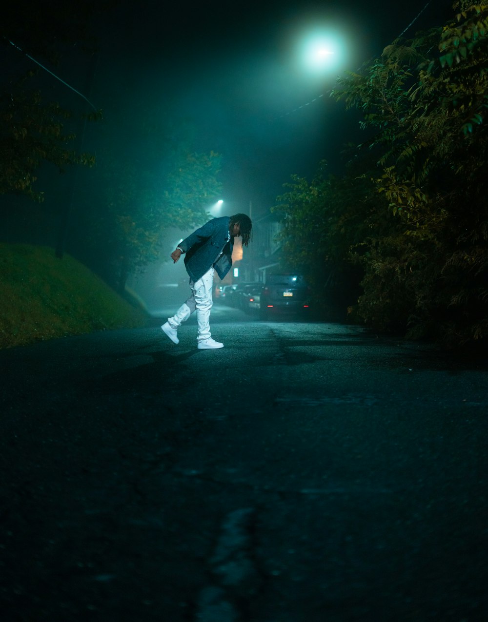 person wearing grey coat standing on the road