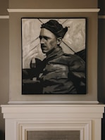 A black and white painting of a person wearing a cap, dressed in what appears to be military attire, is mounted on a wall above a fireplace. The artwork captures a somber expression, with strong shadows accentuating the features.