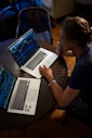man sitting in front of the MacBook Pro