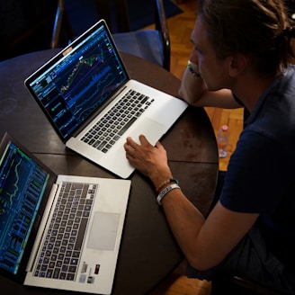 man sitting in front of the MacBook Pro