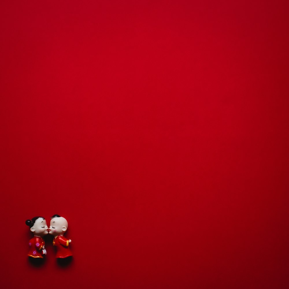 girl and boy wearing red dress figurines