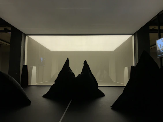 A sleek, dark-themed studio space with a large screen displaying a cinematic video frame, bathed in soft ambient lighting.