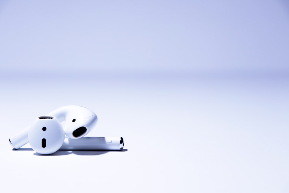 white AirPods on white surface