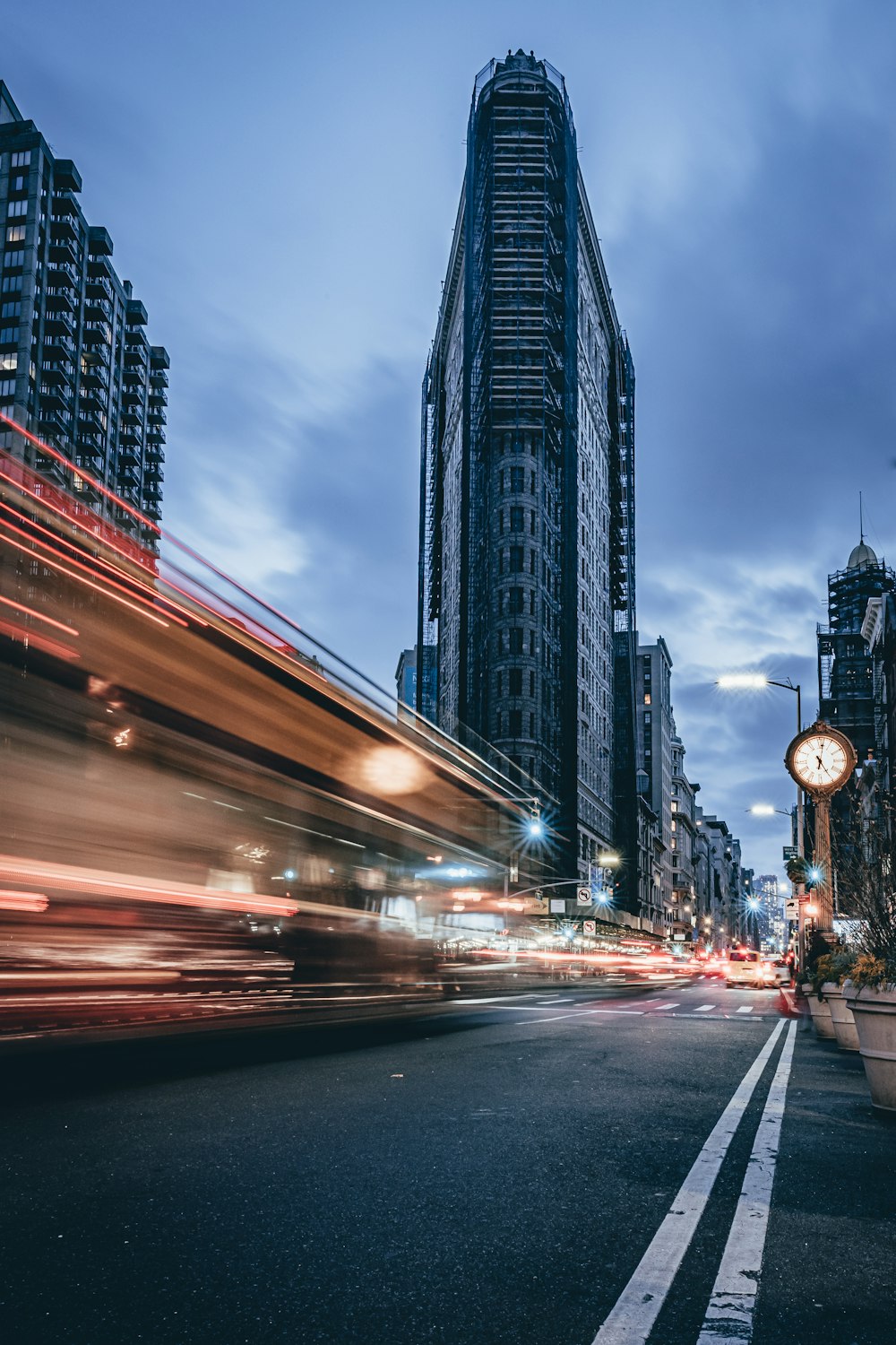 time-lapse photography of vehicles passing on road near Flat Iron building, New York