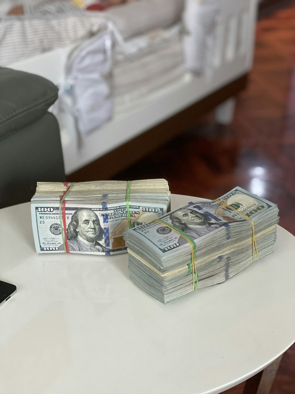 Una pila de dinero encima de una mesa blanca