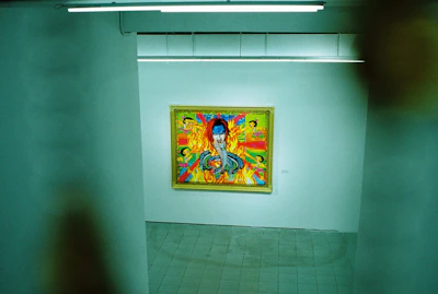 Vivid close-up of a vibrant Brazilian contemporary painting hanging in a sleek gallery space.