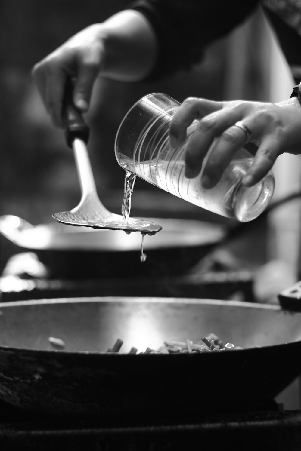person pouring water on wok