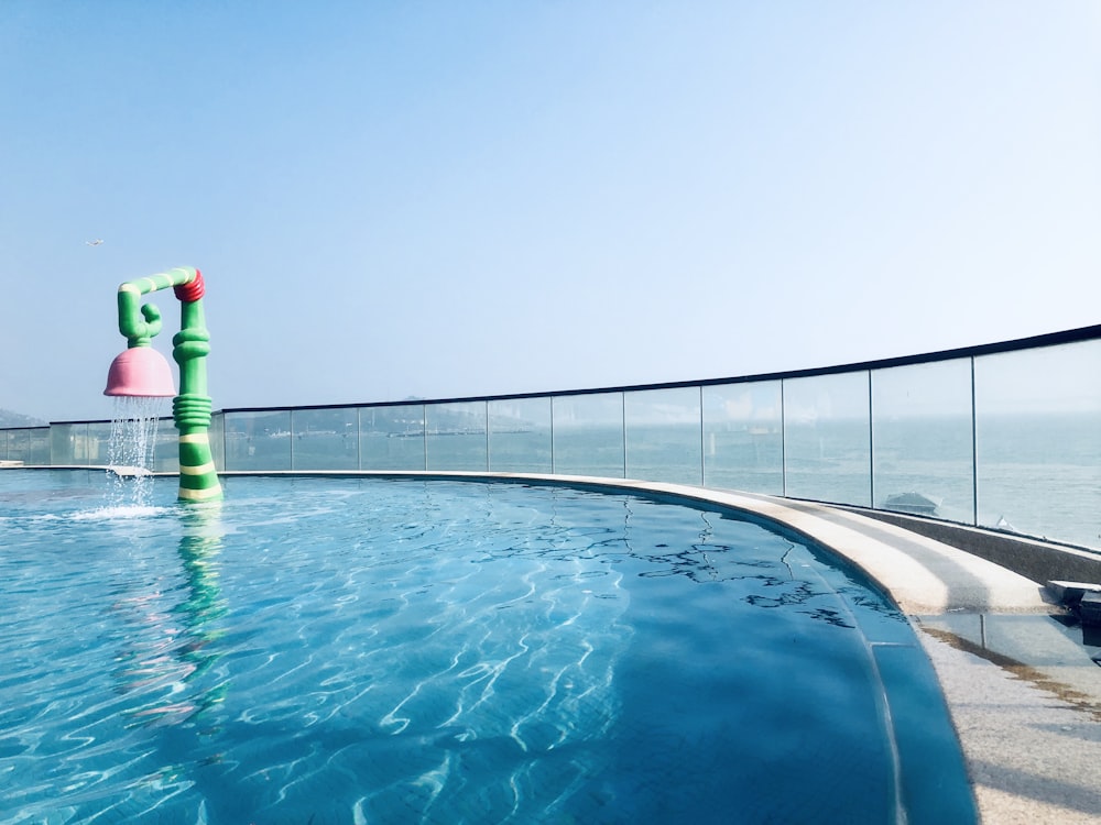 green and pink pipe beside pool