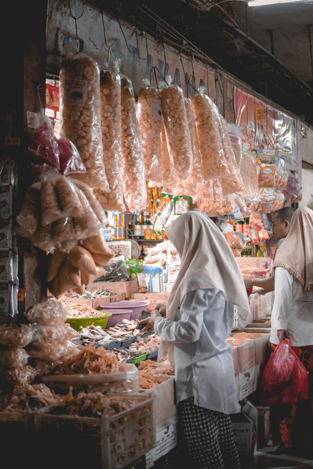 two women wearing hijab standing in front of store