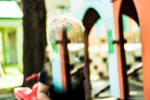 A faded snapshot of a child playing outdoors, full of innocence and joy.