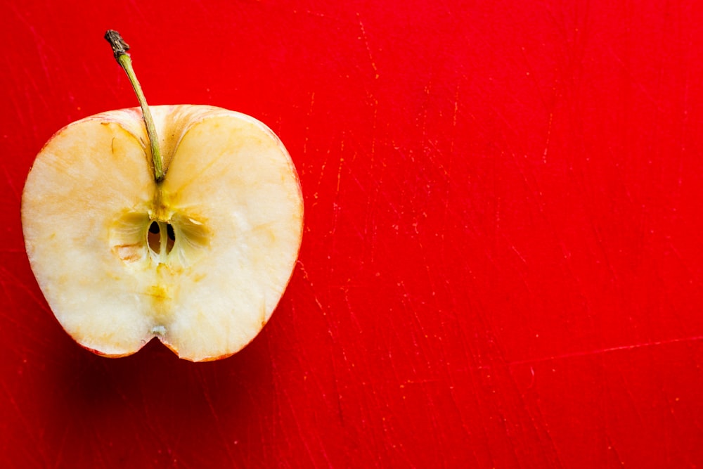 an apple that is sitting on a red surface