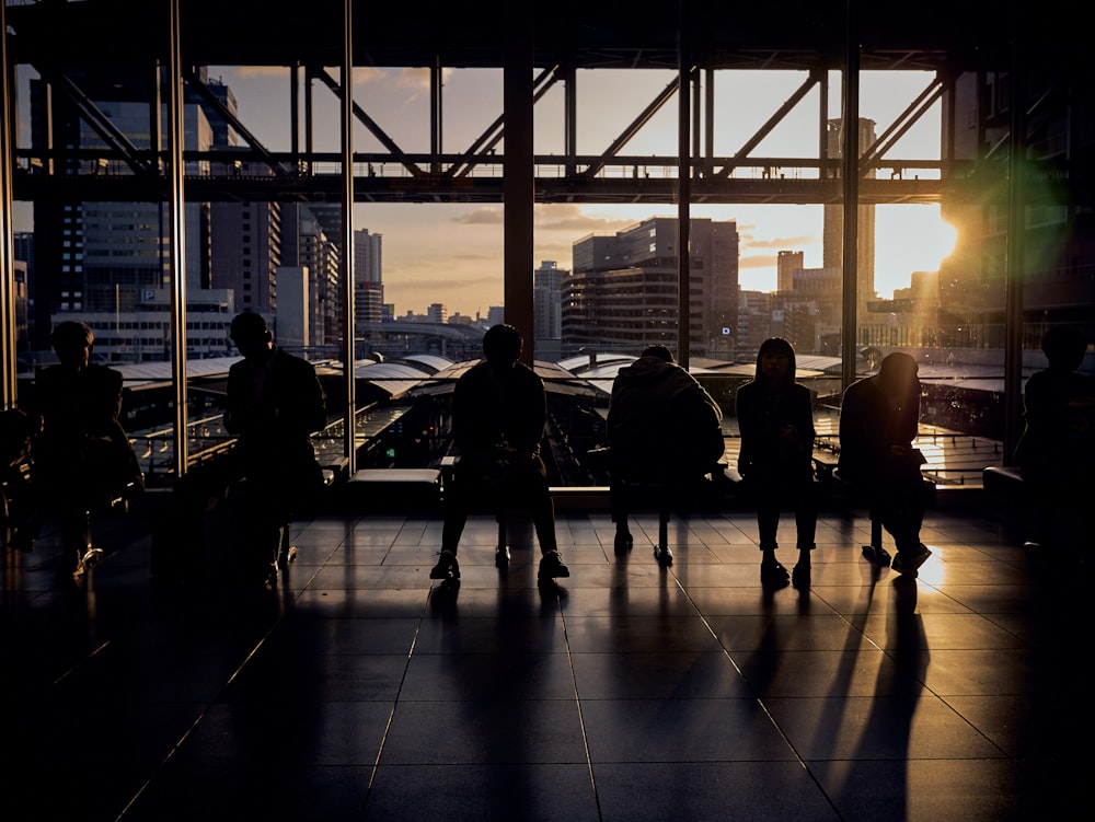 a group of people sitting on a bench in front of a window