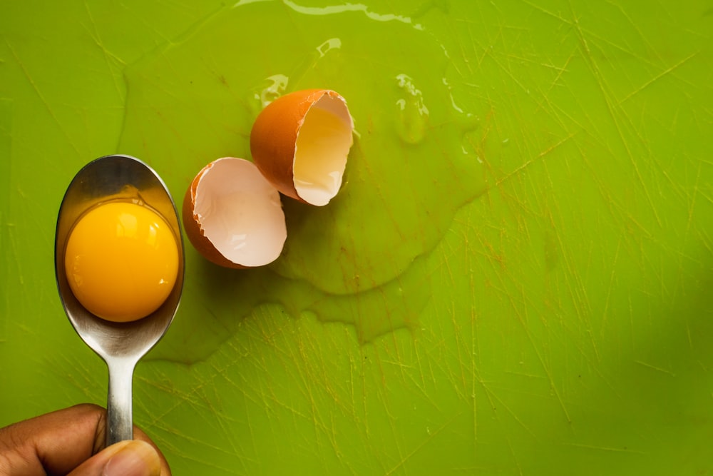 selective focus photography of egg yolk on gray spoon