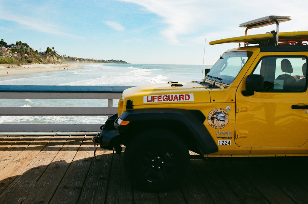 parked brown Life Guard car beside rail
