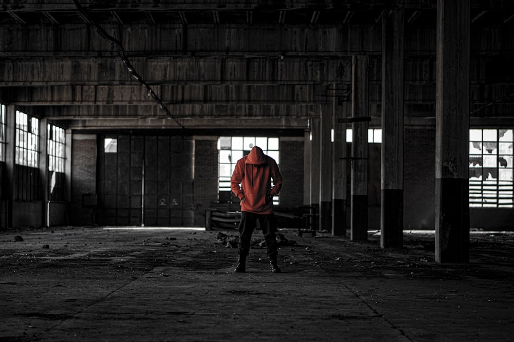 man wearing red hoodie inside building