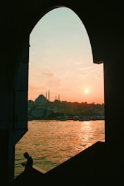 Sunset view of the Western Wall with people praying.