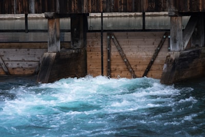 body of water crashing on brown wall intensive teams background