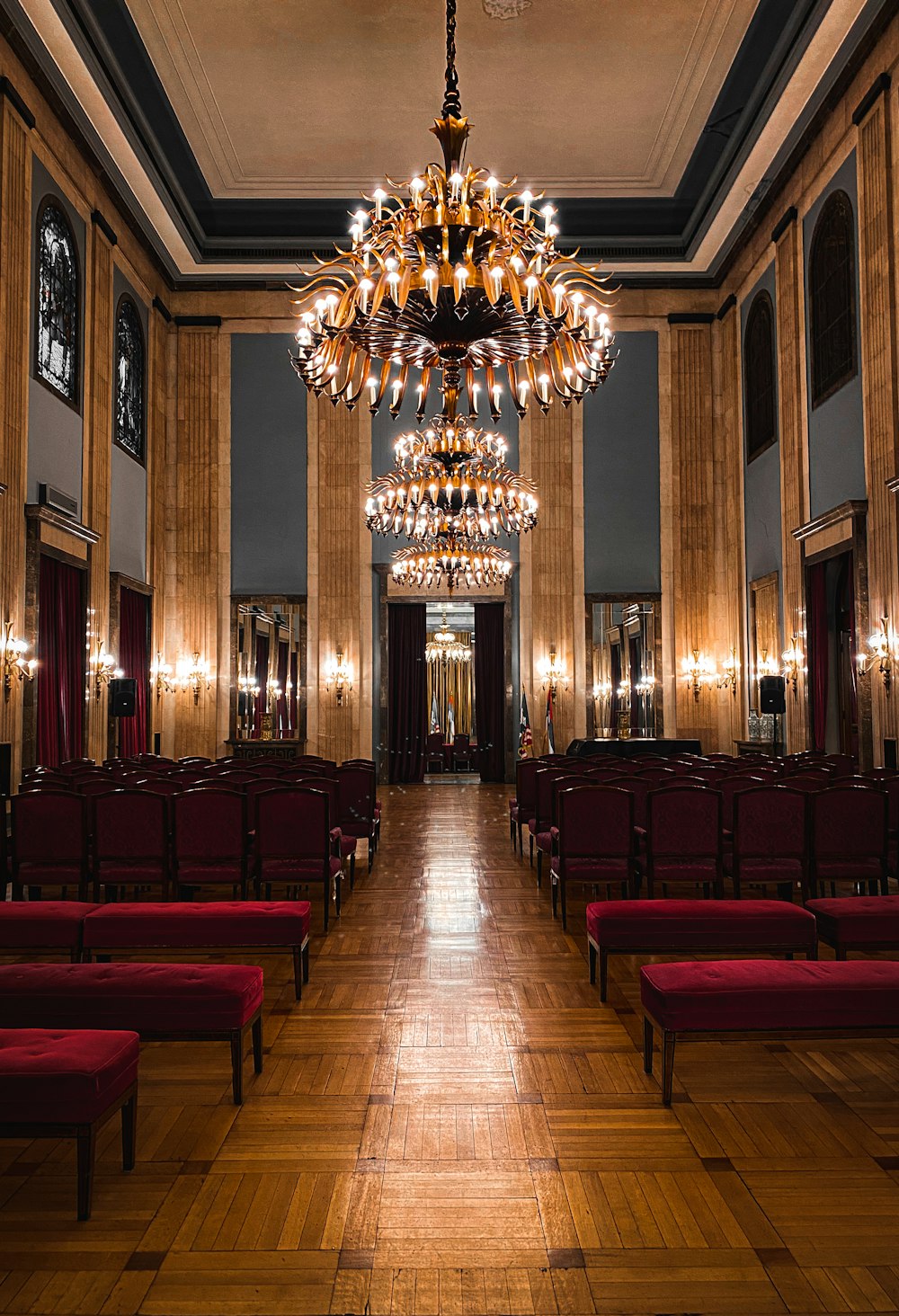 black-and-maroon chairs inside the room with turned-on chandeliner