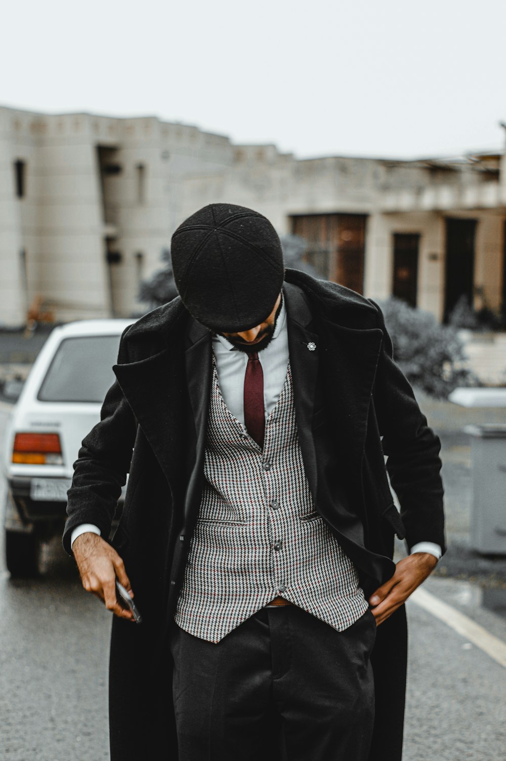 selective focus photography of standing man wearing suit looking down