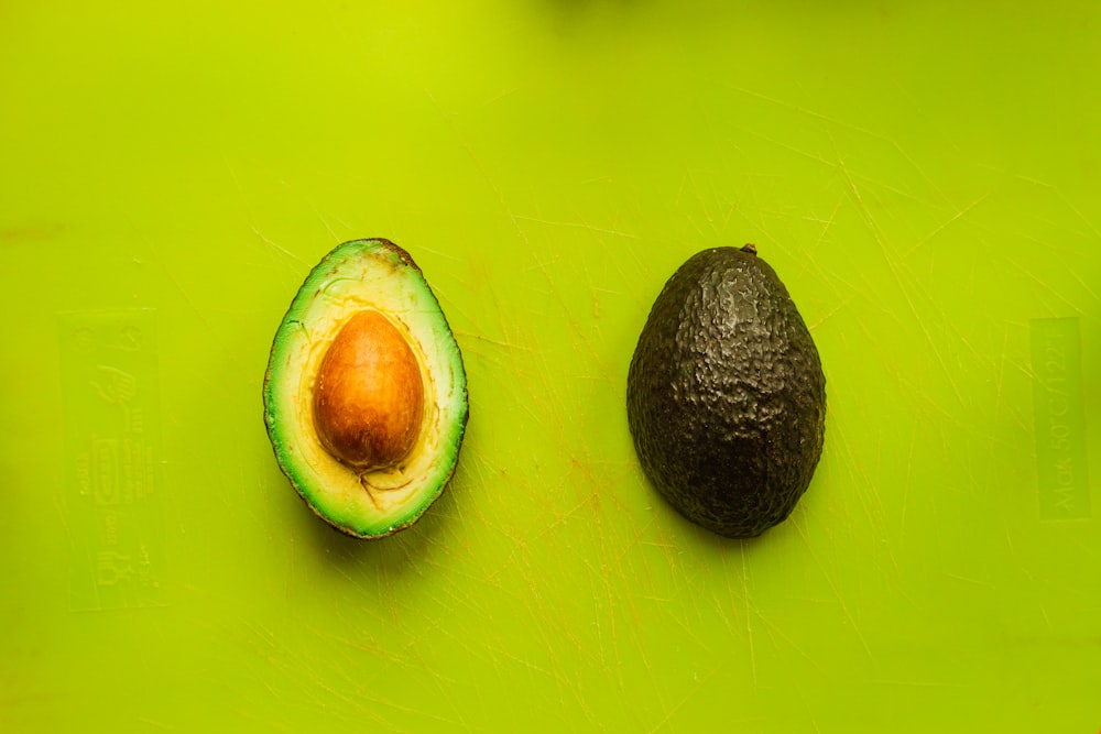 sliced avocado on green surface