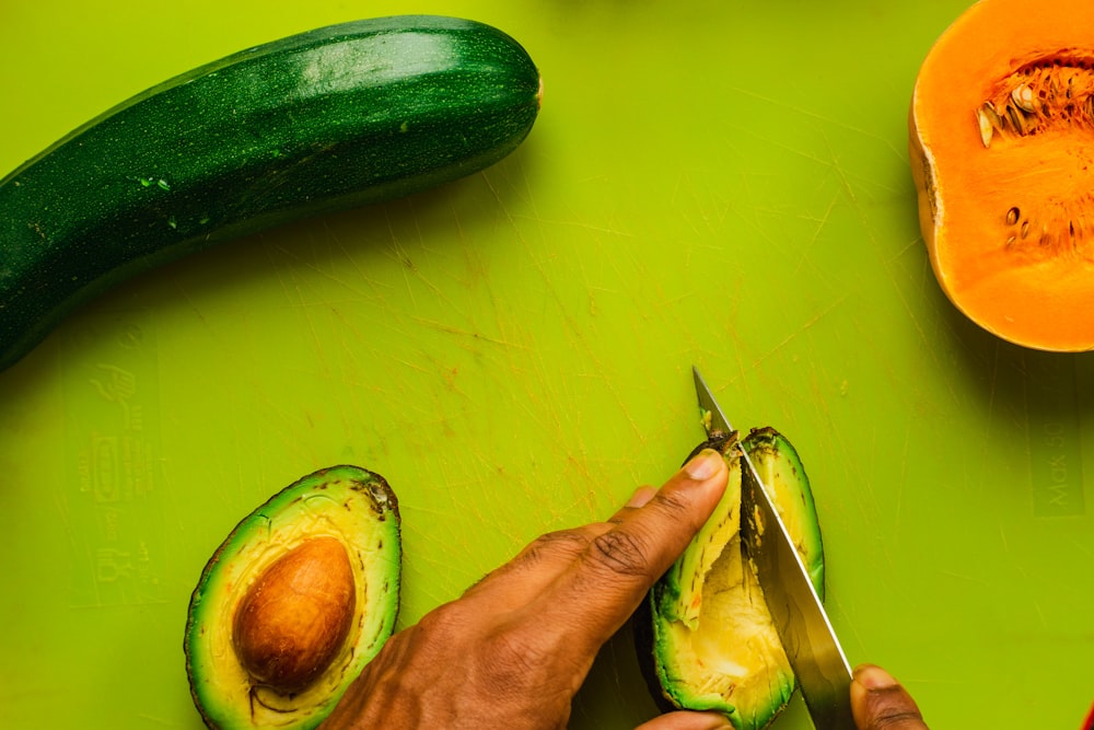 person slicing avocado fruit