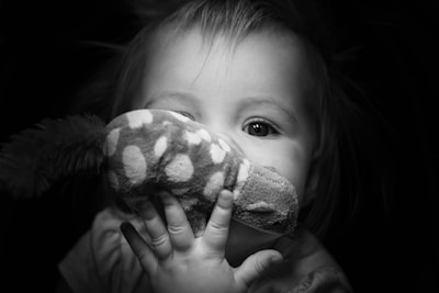 A close-up of a child's hand holding a toy.