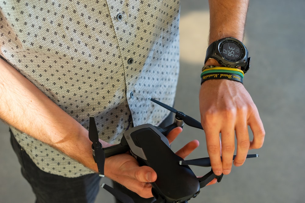 person holding black quadcopter drone